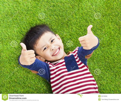 Smiling Kid Lying And Thumb Up On A Meadow Stock Photo Image Of Asian