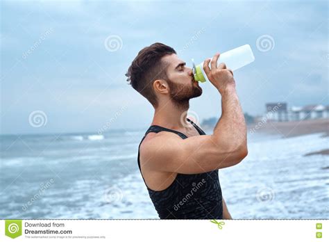 Man Drinking Refreshing Water After Workout At Beach