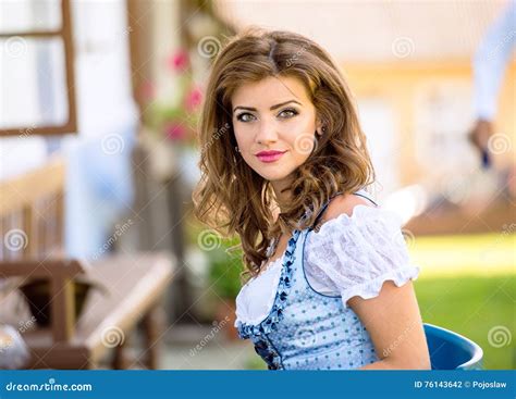 Beautiful Young Woman In Traditional Bavarian Dress In Park Stock Photo