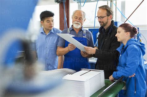 Factory Workers With Supervisor Stock Photo