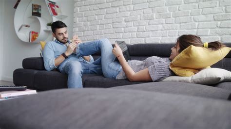 Man Massaging Girlfriend Feet On Sofa At Home Stock Footage SBV Storyblocks