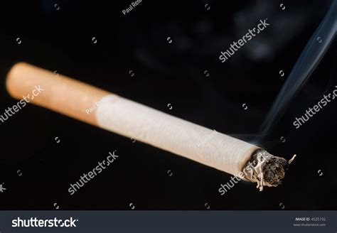 Lit Cigarette On Black Background With Smoke Stock Photo 4525192