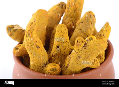 Dry Turmeric Roots Or Barks In Clay Pot Isolated On White Background