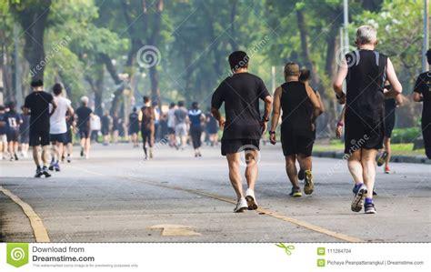 View Of Back Of People Run And Walk At Pedestrian Garden Park Editorial