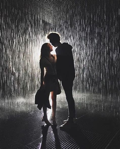 Two People Standing In Front Of A Rain Shower With Their Faces Close To Each Other