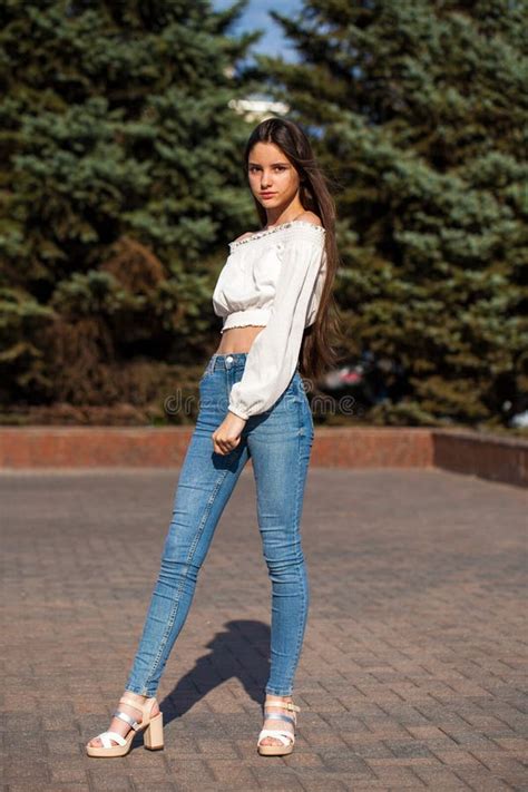Pretty Stylish Brunette Girl In Blue Jeans And White Blouse Stock Image