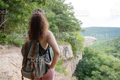 back of curly haired redhead woman looking at whitaker point in ozark national forest arkansas