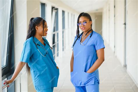 Premium Photo Two Female Friendly Cheerful Doctors Or Nurses In Office