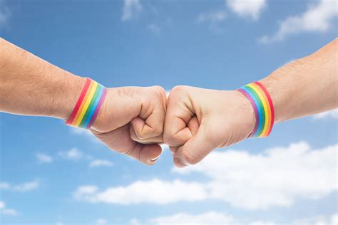 hands with gay pride wristbands make fist bump hab queer bern