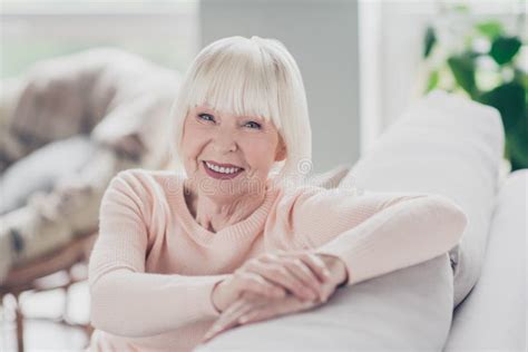 Photo Portrait Smiling Granny Sitting On Soft Sofa In Warm Sweater
