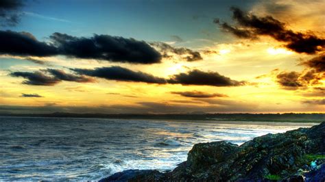 1920x1080 Rocks Shore Sunset Clouds Sea Coolwallpapersme