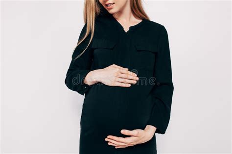 Pregnant Happy Woman In Black Dress Fashion Shot In The Studio On A