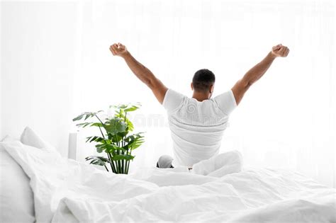 Satisfied European Millennial Guy Wakes Up After Rest Stretching Body