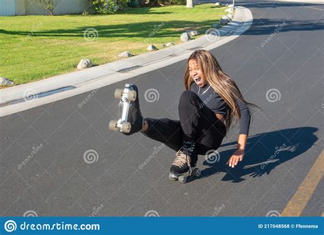 Young African American Women Falls Roller Skating On Street Stock Photo