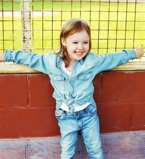Portrait Of Smiling Little Girl Child In The Jeans Clothes Stock Photo