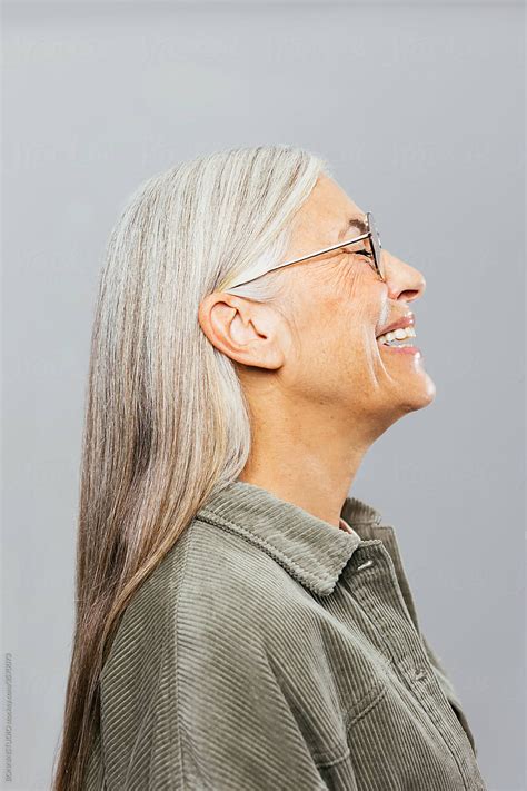 Optimistic Elderly Female In Glasses Laughing Cheerfully By Stocksy