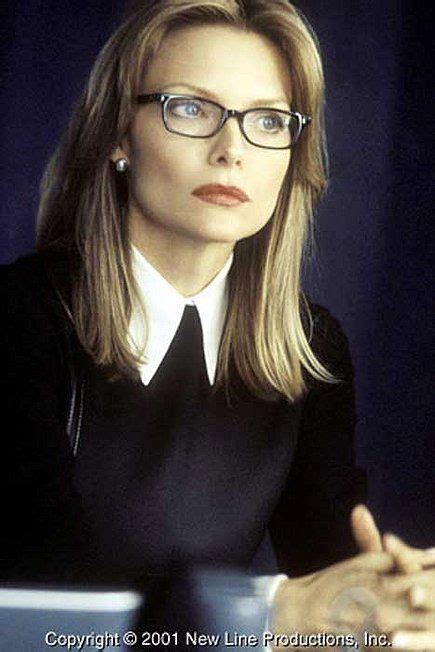 A Woman Wearing Glasses And A Black Shirt Is Looking At The Camera With