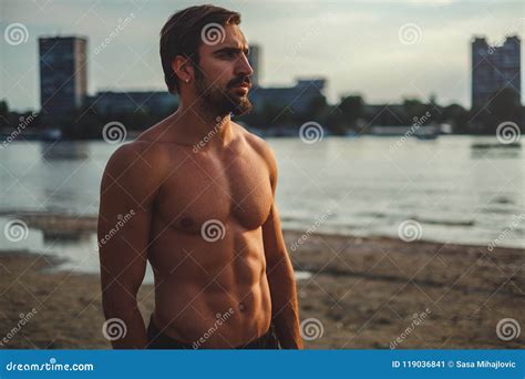 Shirtless Muscular Man Standing On The City Beach Alone Stock Image