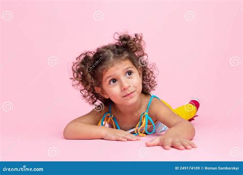 Portrait Of Attractive Cute Funny Wavy Haired Girl Lying On Floor Crawling Over Pink Pastel