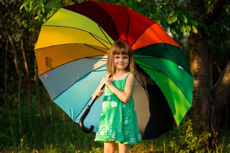 Happy Child Girl Walk With Multicolored Umbrella Under Rain Stock Image
