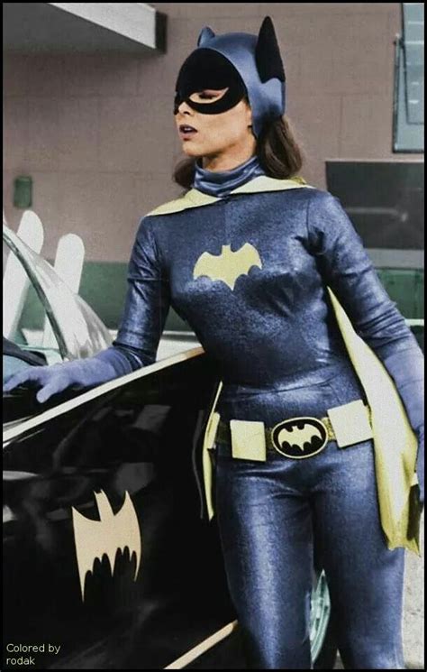 A Woman Dressed In Batman Costume Standing Next To A Car