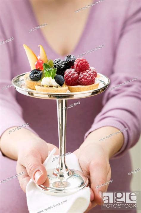 Woman Serving Assorted Berry Tarts Stock Photo Picture And Rights