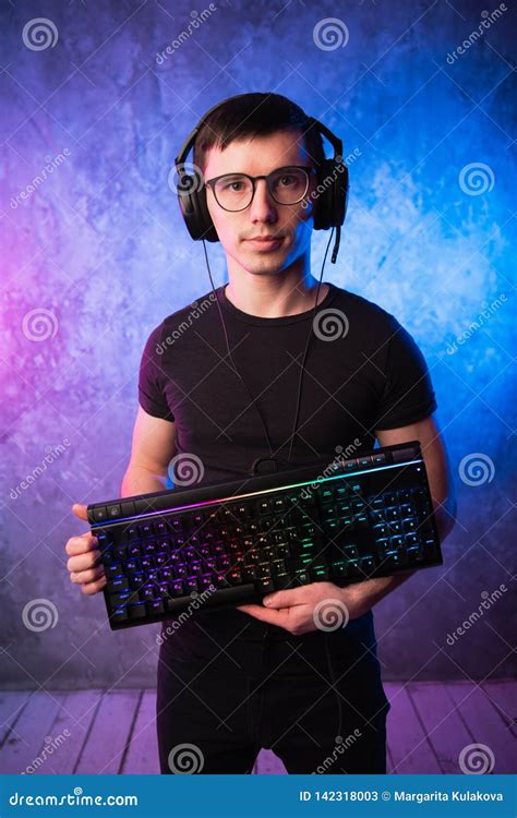 Professional Boy Gamer Holding Gaming Keyboard Over Colorful Pink And