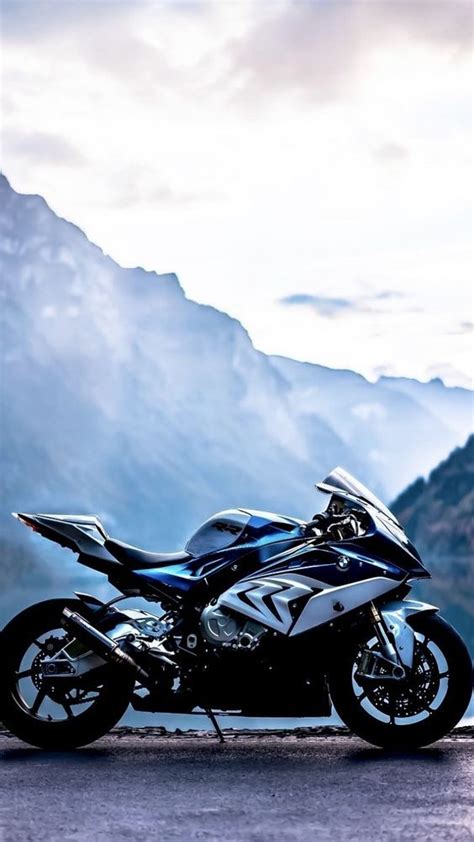 A Black Motorcycle Parked On The Side Of A Road Next To Some Mountains