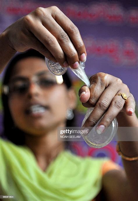 Indian Programme Officer G Shilpa Poses With A Female Condom At An