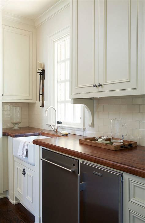 In this vermont farmhouse kitchen, crisp white painted cabinetry pairs with warm woods, unlacquered brass hardware, and black accents for a timeless look that is fresh and inviting. Traditional Off-White Kitchen with Brick Backsplash - Home ...