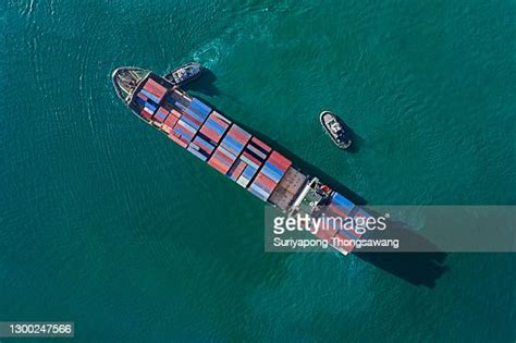 Aerial Top View Tugboat Pulling Container Cargo Ship Going To Loading