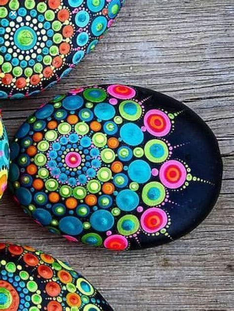 Three Painted Rocks Sitting On Top Of A Wooden Table