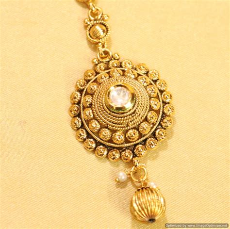 This heavy gold maang tikka with chains and green drops. Buy Antique gold Look Kundan Maang Tikka Online