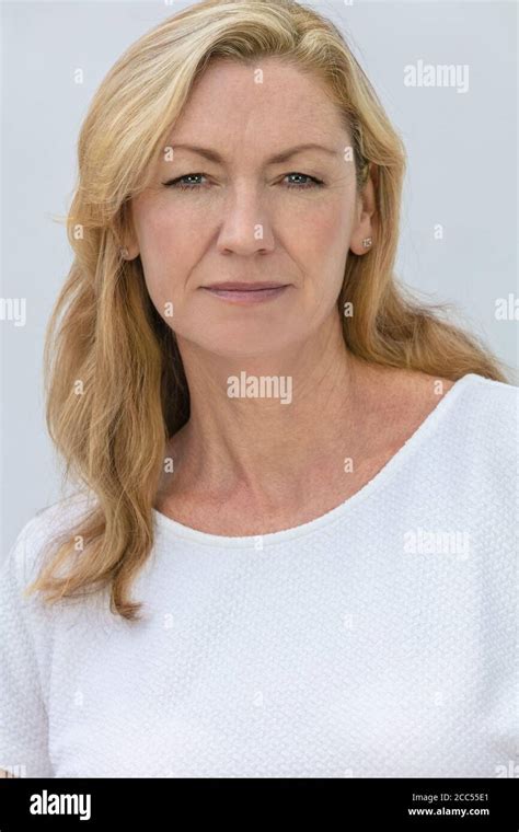 Studio Portrait Of An Attractive Middle Aged Blonde Woman Smiling On A White Background Stock