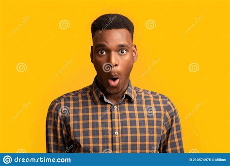 Portrait Of Surprised African American Guy Opened Mouth In Amazement Yellow Background Stock