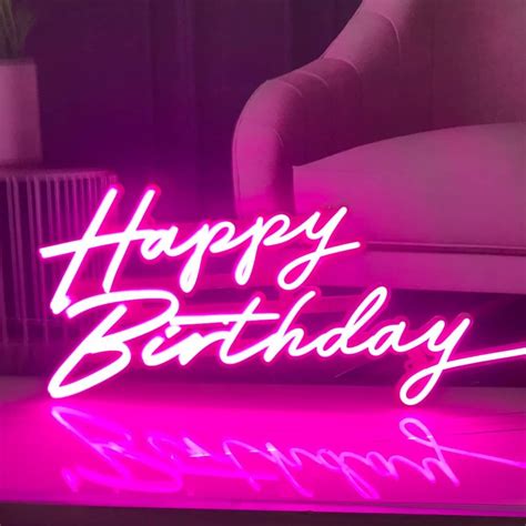 A Happy Birthday Neon Sign Sitting On Top Of A Table