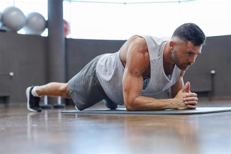 Portrait Of A Fitness Man Doing Planking Exercise In Gym Stock Image