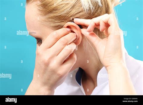 Young Woman Assumes A Hearing Aid Stock Photo Alamy