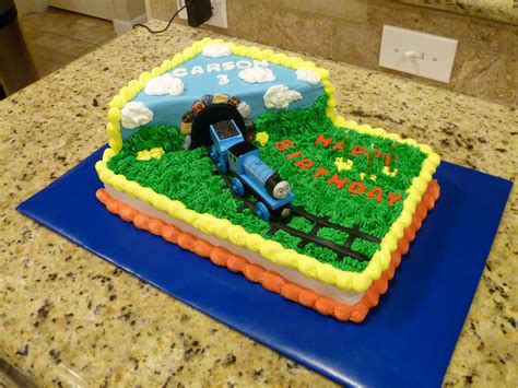 A Birthday Cake That Is Shaped Like A Farm Scene With A Tractor On The Grass