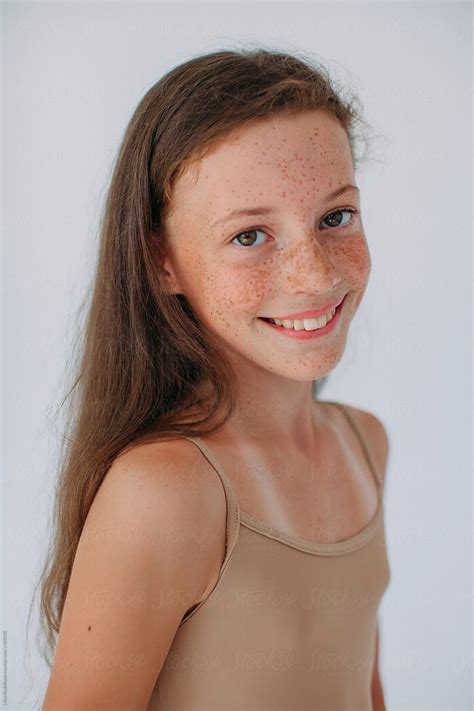 Lovely Girl With Freckles And Happy Smile Posing At Studio And Looking