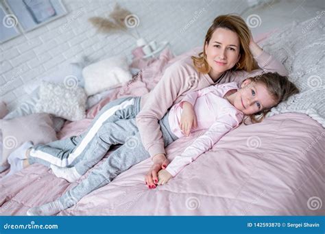 Beautiful Young Mother And Her Little Daughter Are Lying Together On