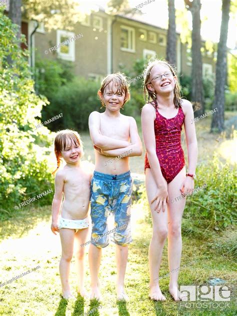 Wet Brother And Two Sister Standing In Garden Stock Photo Picture And Royalty Free Image Pic