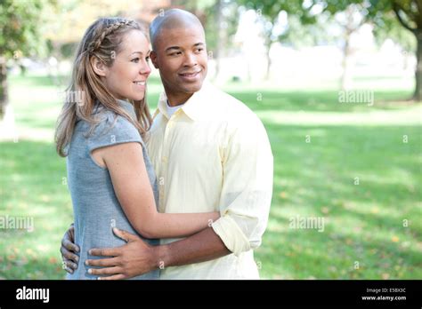 A Happy Young Interracial Couple Looking To The Right Side Stock Photo