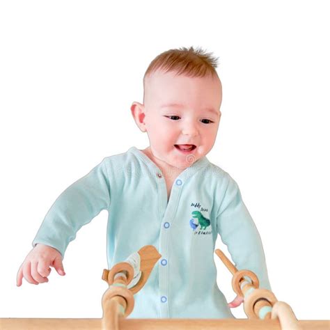 Happy Infant Baby Is Playing With Wooden Hanging Toys Lying In Bed Iso