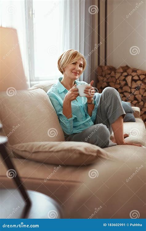 Mature Woman Beautiful Healthy Middle Age Female Sitting On Sofa At