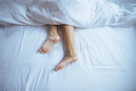 Close Up Of Barefootfeet And Stretch Lazily On The Bed Stock Photo