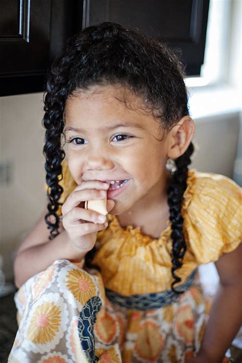 Pulling her braids into a shower cap in the bath. Biracial hair care routine for kids