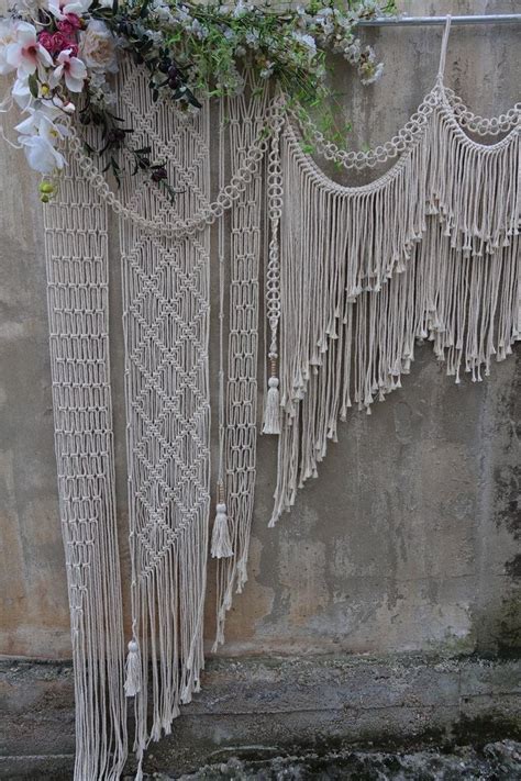 Macrame Wall Hangings With Flowers And Greenery On The Side Of A Building