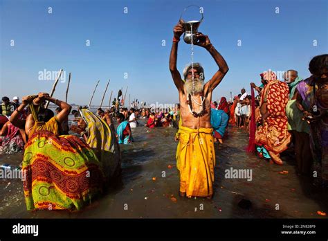 An Indian Devotee Prays To The Sun God As Others Take Holy Dips At Sangam The Confluence Of The