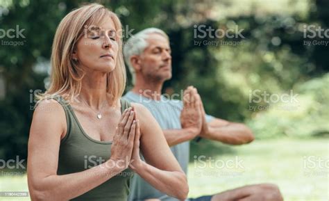 Mature Couple Meditating Together During Yoga Practice Outside Stock